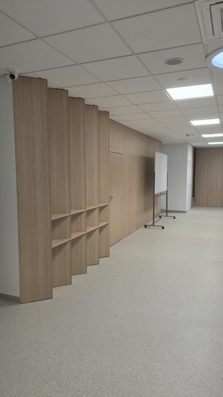 Drevený obklad s policami v priestore čakárne