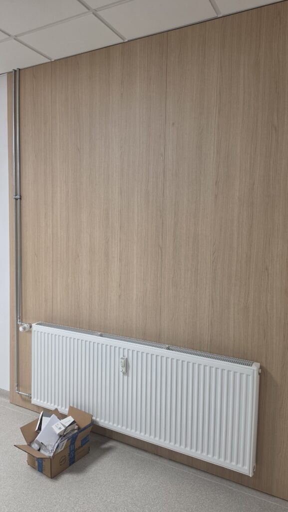 Drevený obklad steny v svetlom dubovom dekore v priestoroch kliniky